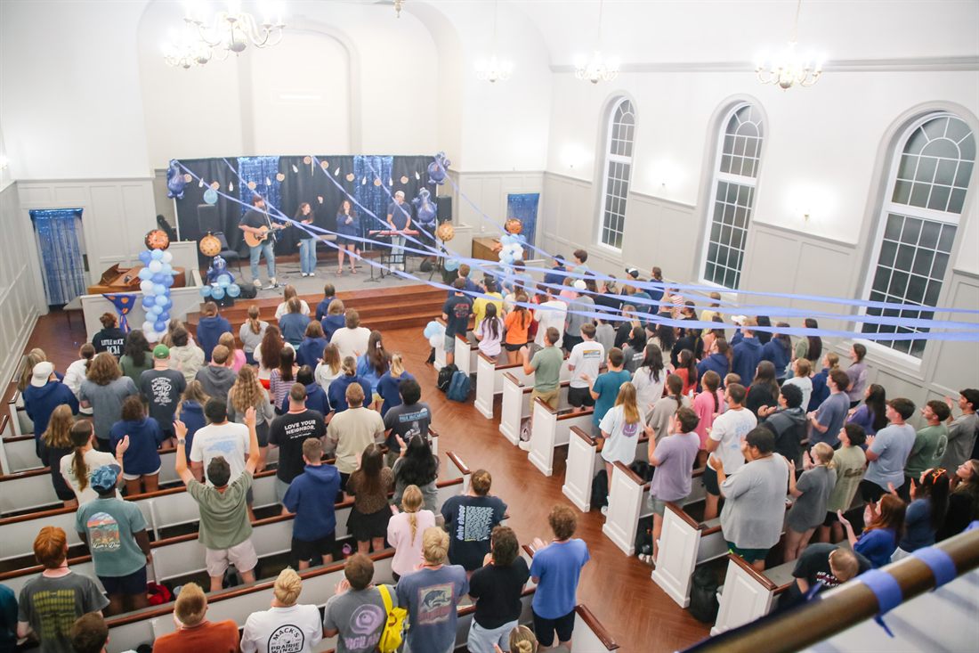 Students standing for worship in the chapel