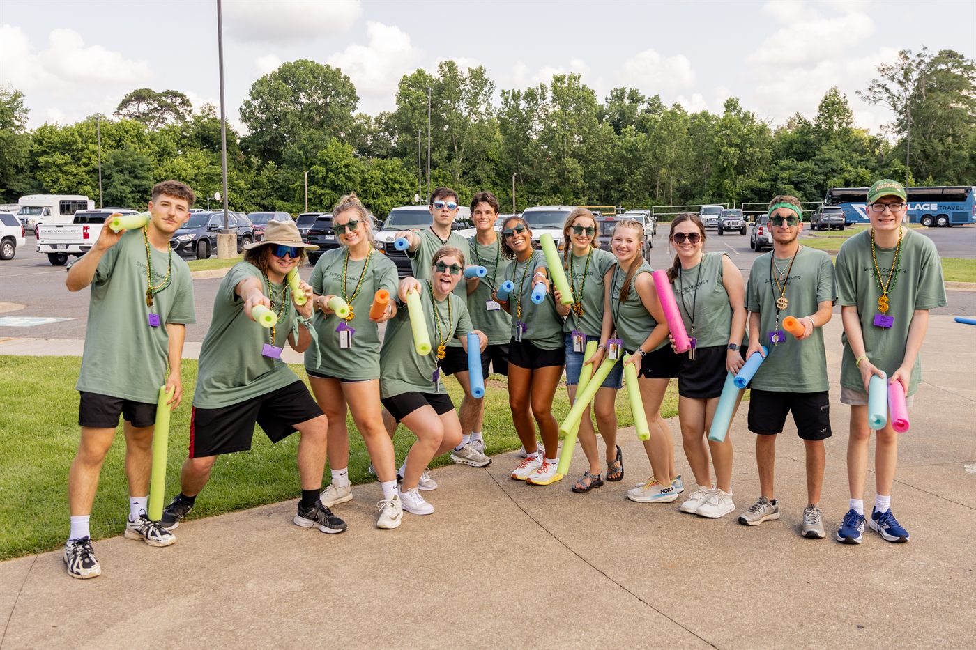 Staffers with pool noodles ready to welcome students on arrival day